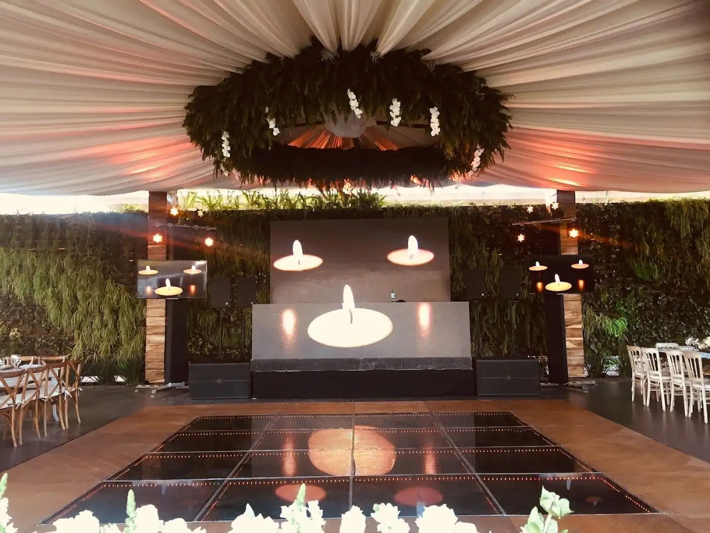 Escenario con corona floral, telas y pista en el salón de El Caracol